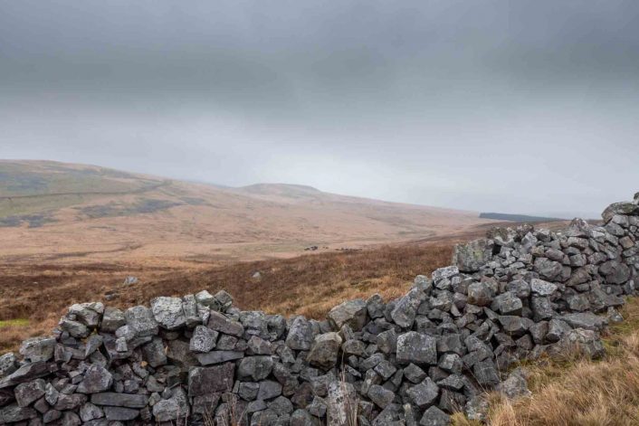 Looking towards the Brecon Beacons from a stone wall on a rainy winter's day